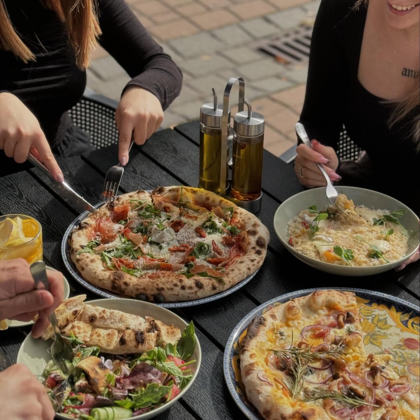 Wspólny stół z pizzą, risotto i sałatką w ogródku
